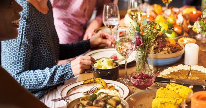 People gathered around a table filled with food for the holidays.