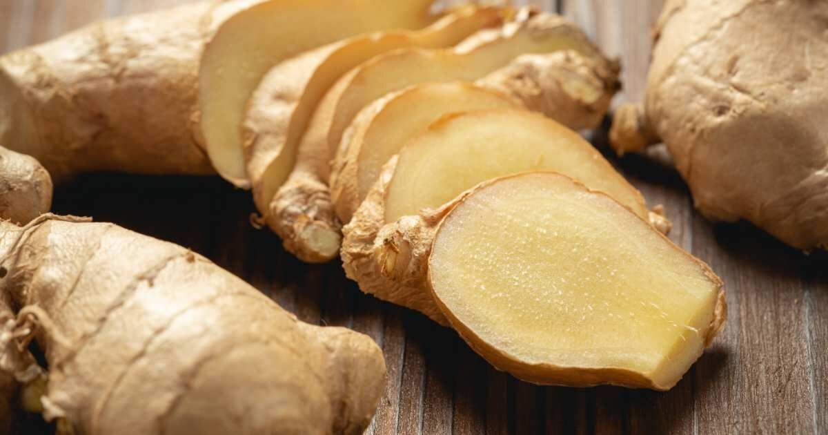Sliced ginger root on a wooden surface.