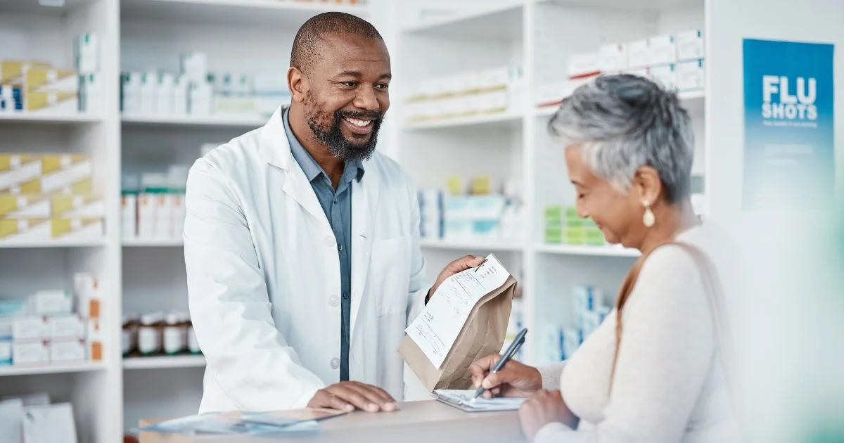 Pharmacist assisting customer with prescription pickup