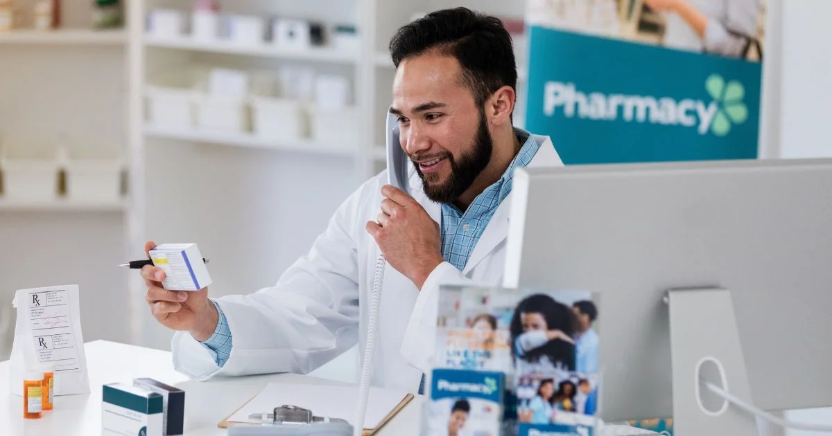 Pharmacist speaking on phone while reviewing prescription