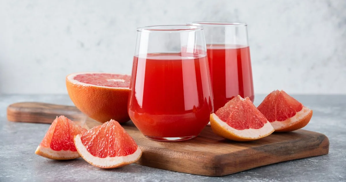 Fresh grapefruit juice with sliced grapefruit on board