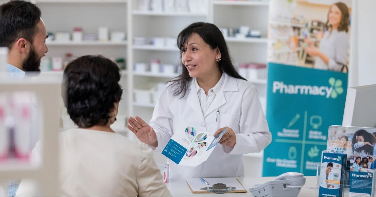 Pharmacist consulting with customers at pharmacy counter
